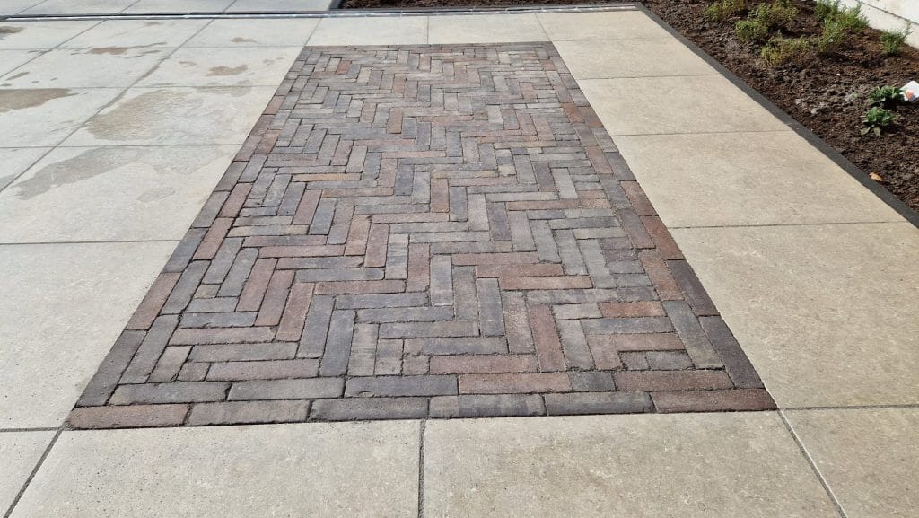 Detail gebakken klinkers in visgraat tussen keramische tegels