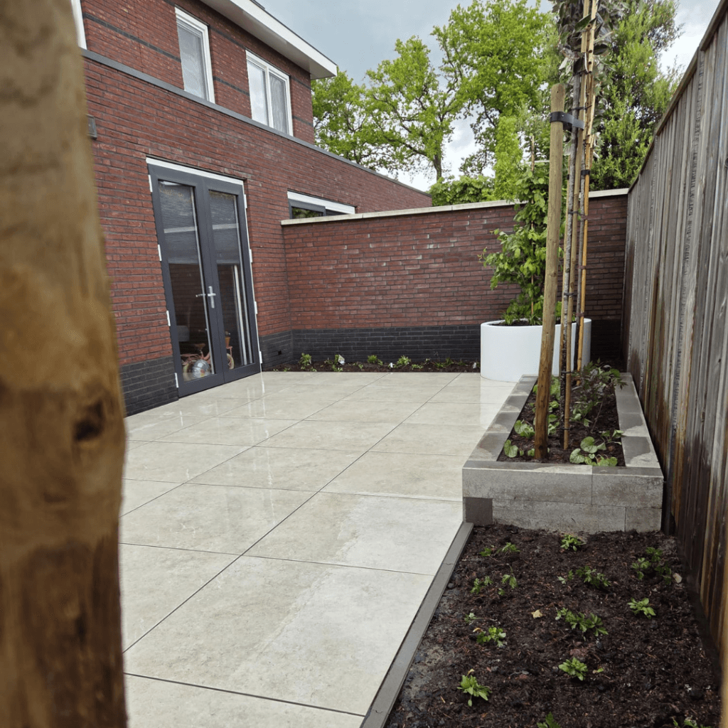 Aangelegde achtertuin Tubbergen met keramisch terras, verhoogde border en leibomen