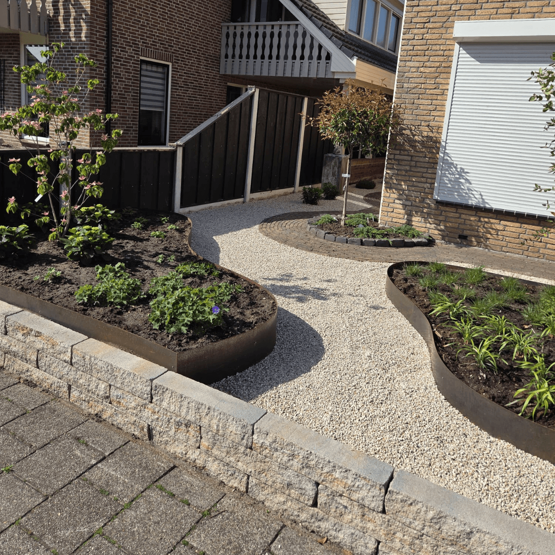 Voortuin Fleringen met grindpad en golvende cortenstaal borders langs de beplanting
