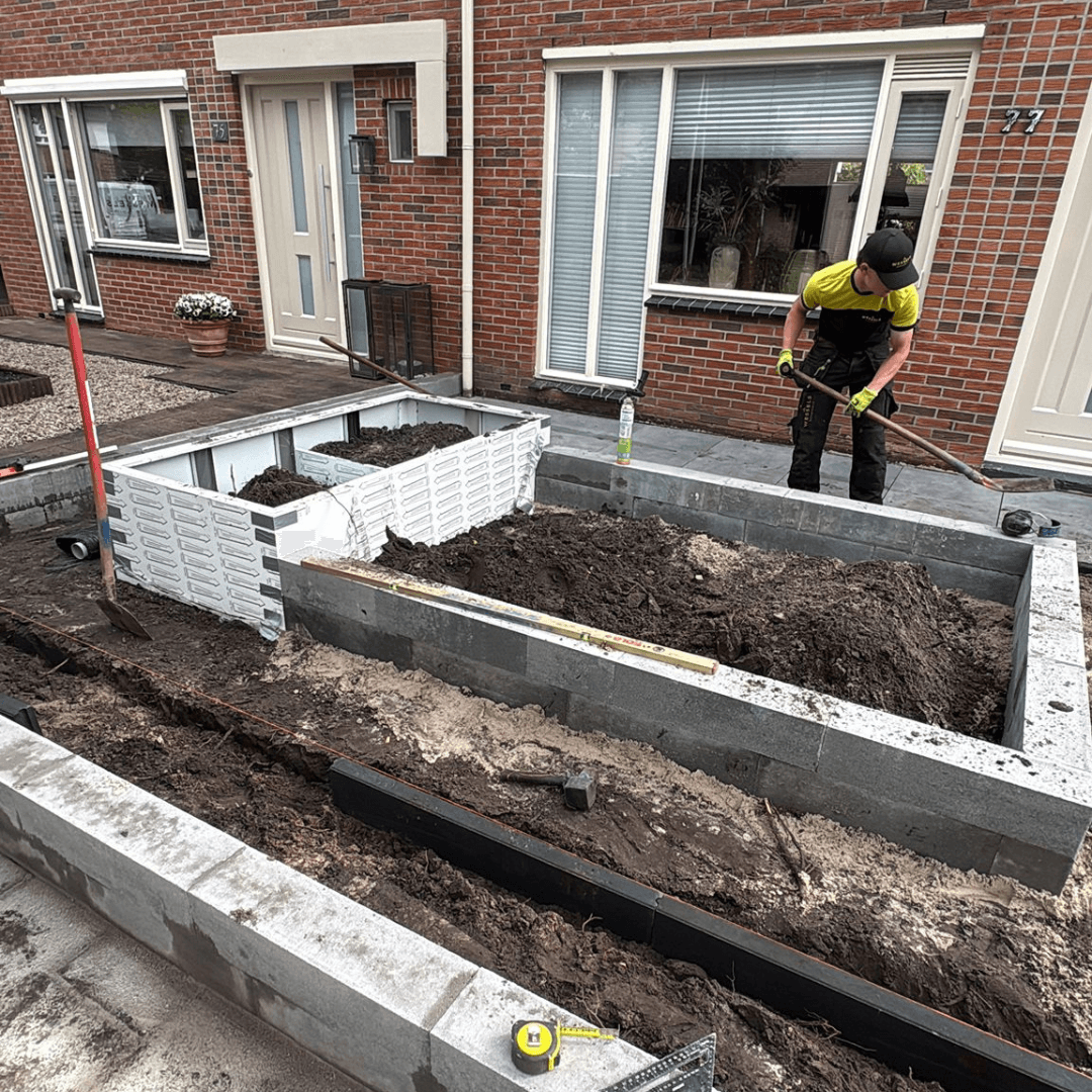 Witte stalen bloembak in verhoogde border van de voortuin in Vriezenveen
