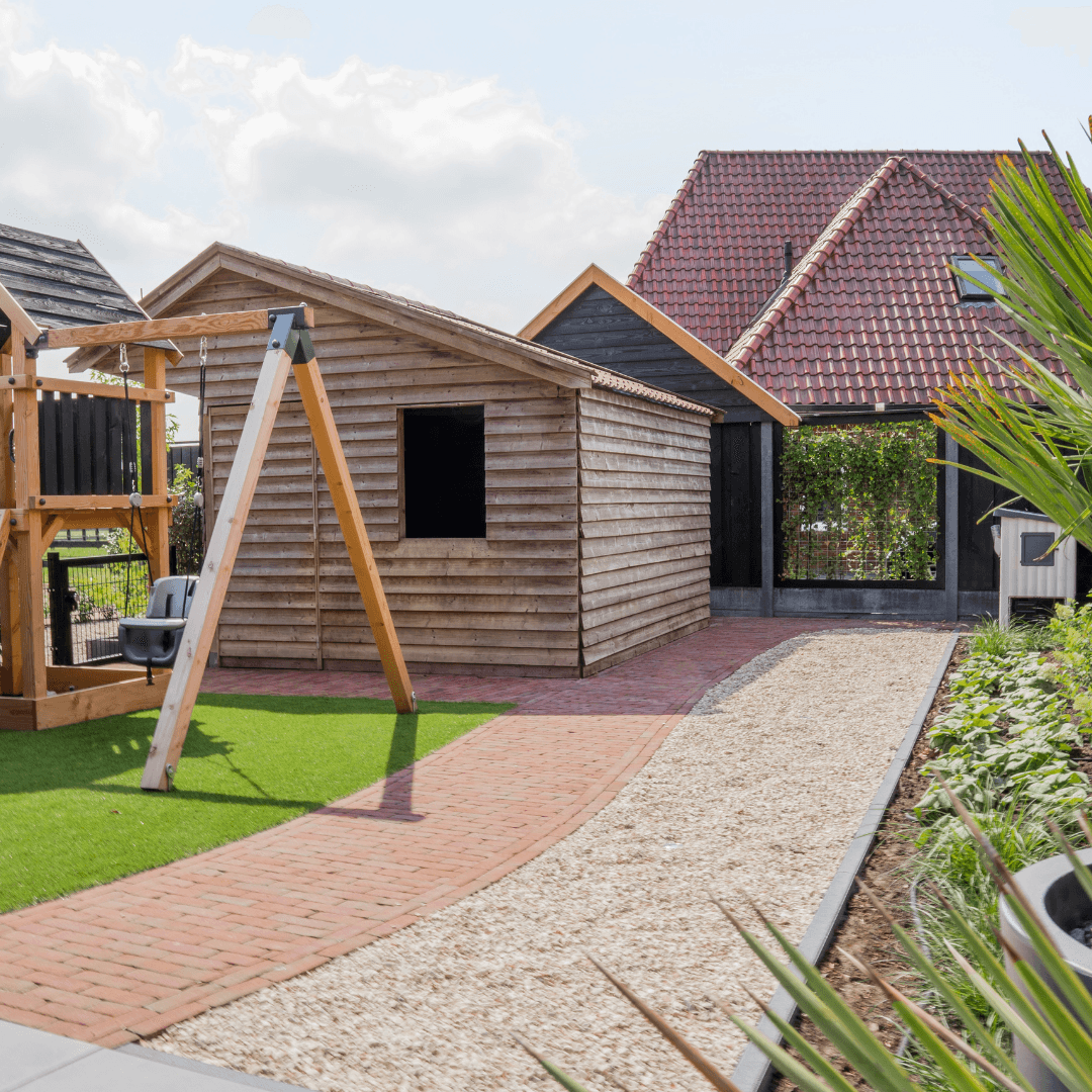 Speelhuisje met schommel en kunstgras op het priveterras bij Erve Tijhuis in Langeveen