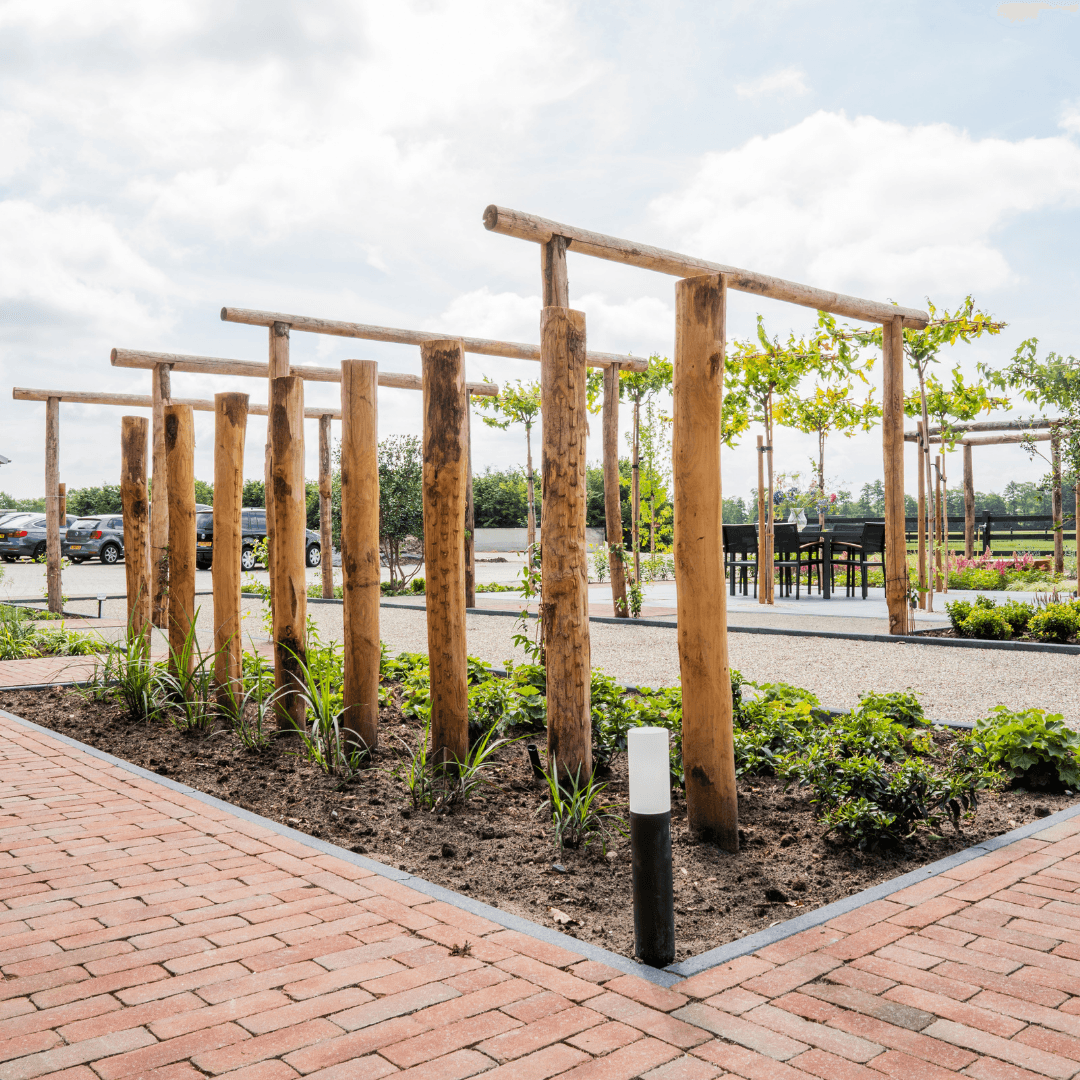 Kastanjehouten palen met bollardverlichting in een border van de tuin in Langeveen