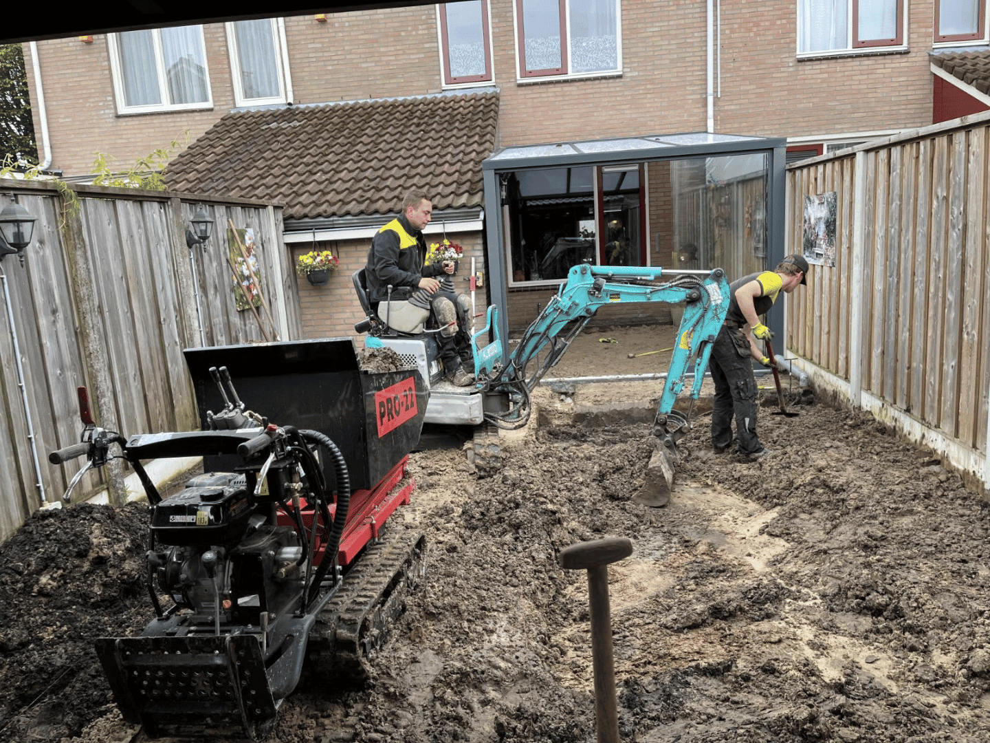 Achtertuin De Lutte tijdens grondwerk met minikraan als voorbereiding van de tuinaanleg