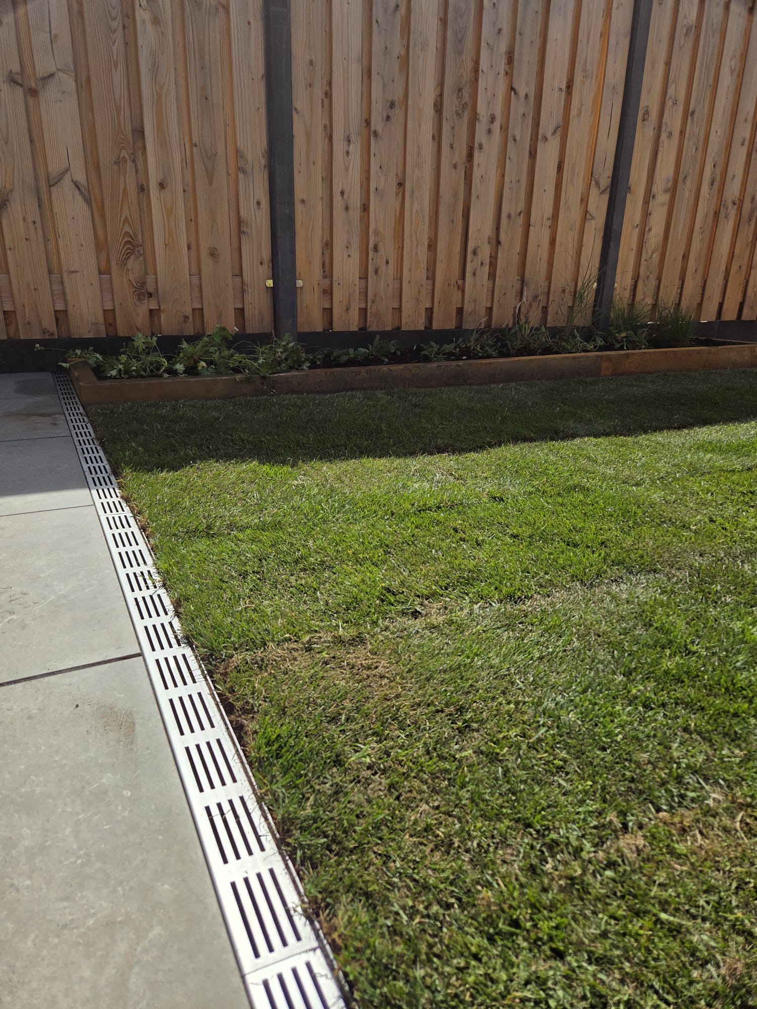 Slimline goot langs het keramisch terras voor de afwatering in stadstuin Hengelo