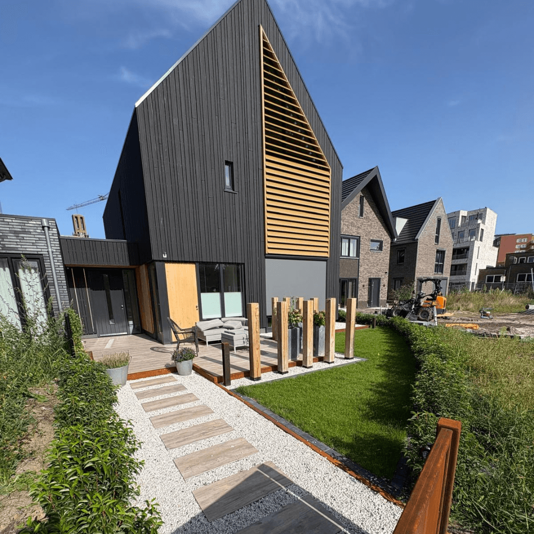 Tuin aanleggen nieuwbouw Hengelo: staptegels in wit grind naar de zwarte houten woning