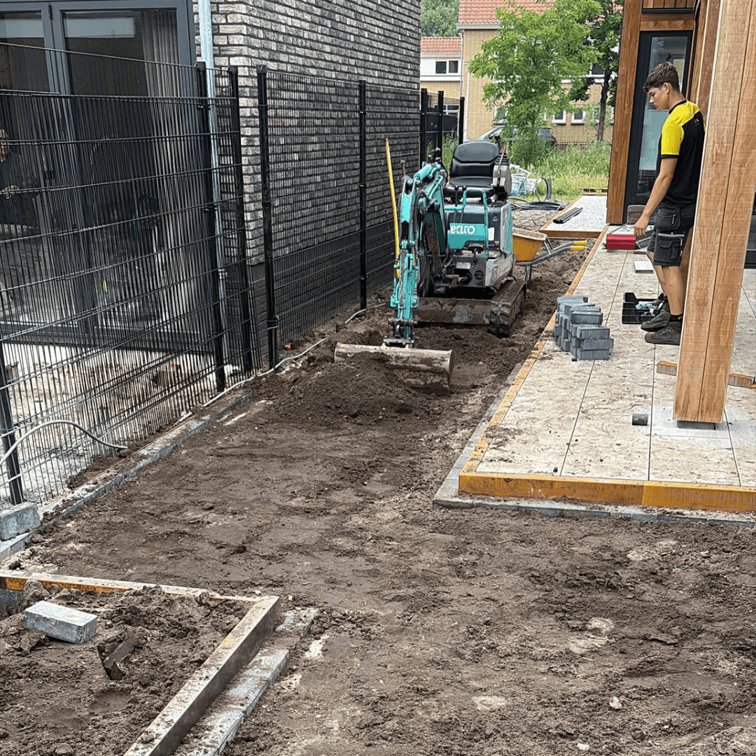 Minigraver bereidt de bouwgrond voor bij het tuin aanleggen nieuwbouw Hengelo