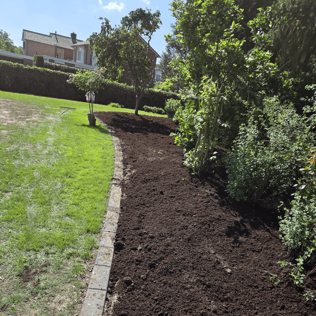 Border met verse tuinaarde langs het gazon in de tuin in Tubbergen