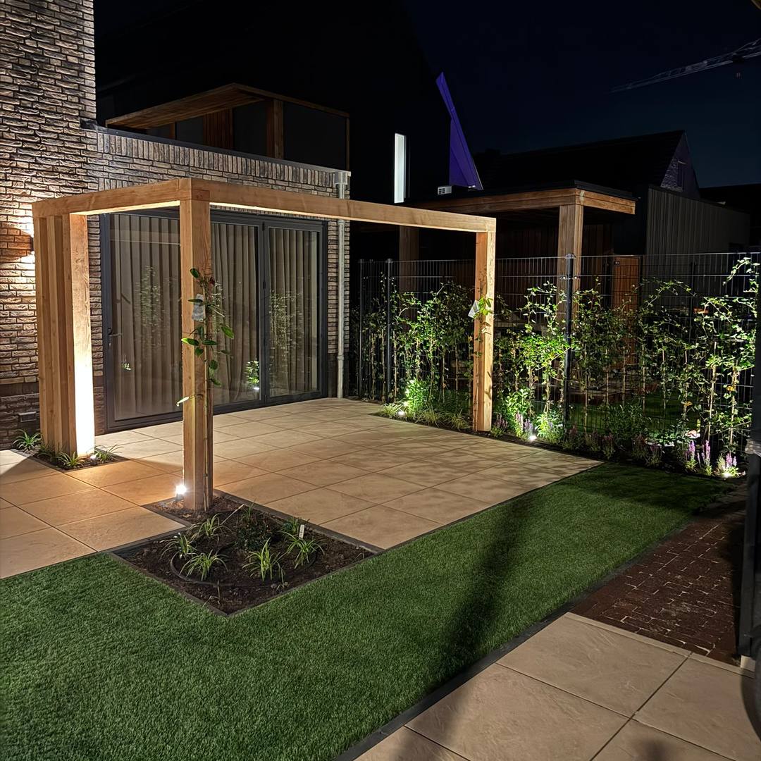 Douglas pergola met grondspot in de achtertuin in Hengelo in de avond