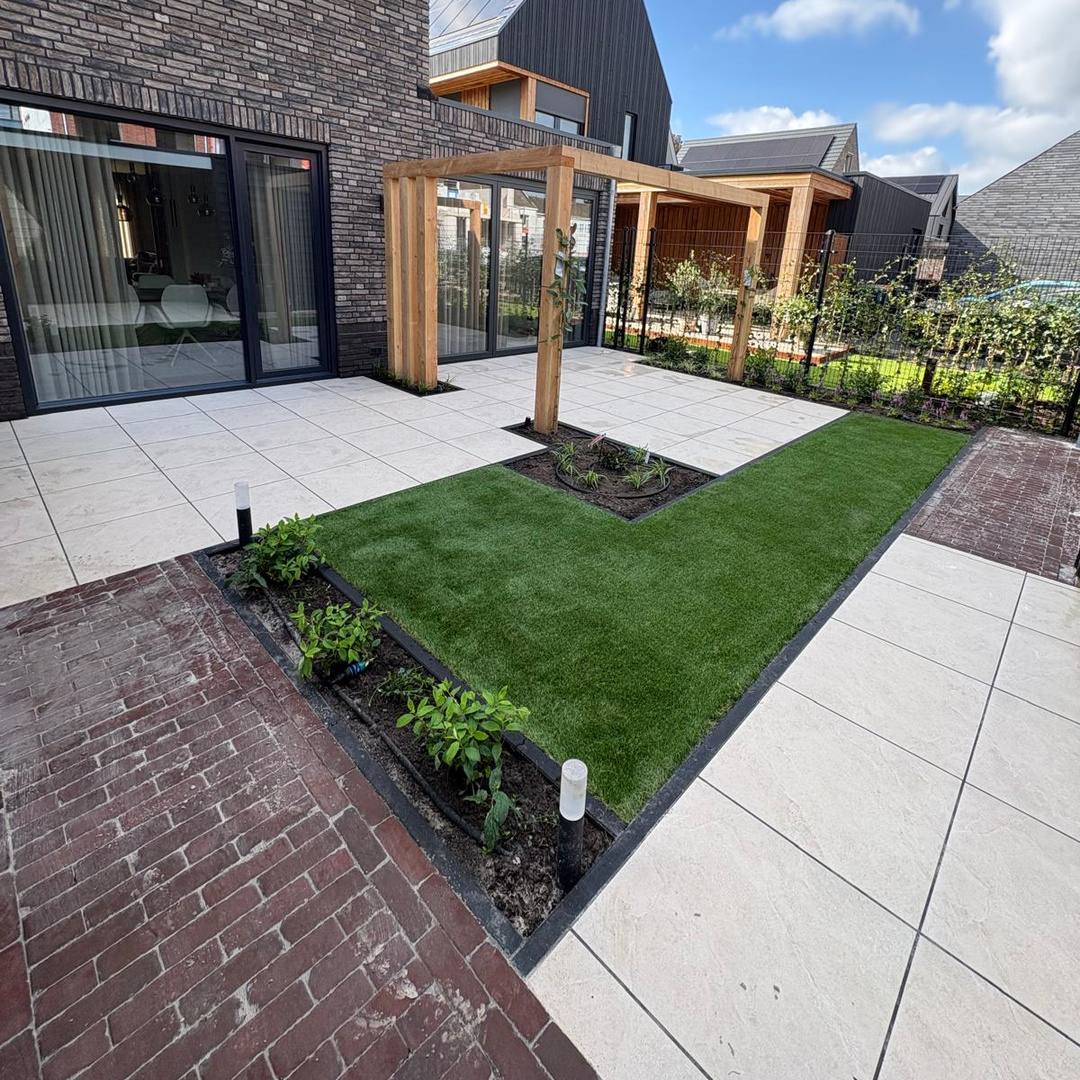 Voor- en achtertuin aanleggen Hengelo: keramisch terras, kunstgras en gebakken klinkerpad bij een Douglas pergola