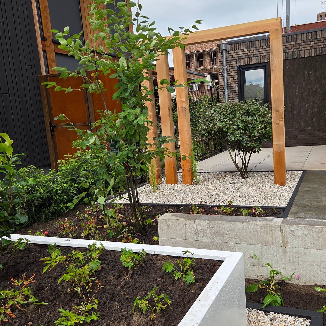 Douglas pergola met klimplanten achter de verhoogde bloembak in de voortuin in Hengelo