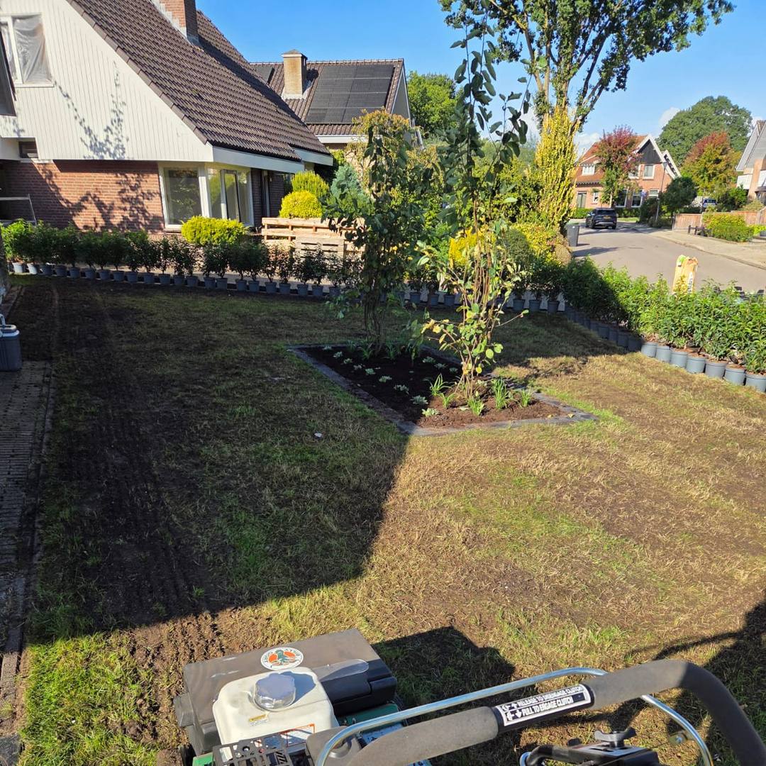 Gazon wordt na het verticuteren machinaal doorgezaaid in de voortuin in Albergen